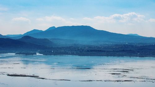 Scenic view of lake and mountains against sky