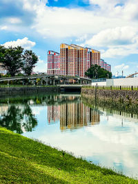 Built structure by lake against sky in city