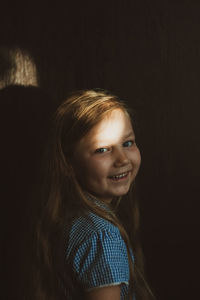 Portrait of smiling girl in dark