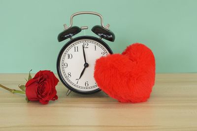 Close-up of clock on table against wall
