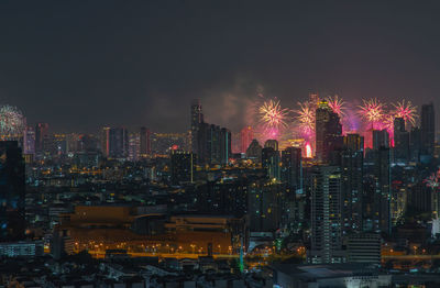 Illuminated cityscape against sky at night