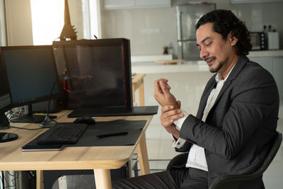 Man using mobile phone while sitting on table