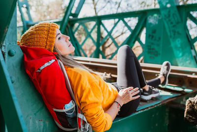 Woman trekking rests on an abandoned old railway bridge