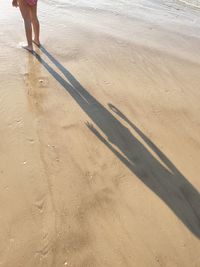 Low section of person on sand at beach