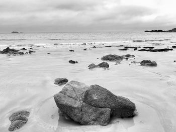 Scenic view of rocks on beach against sky