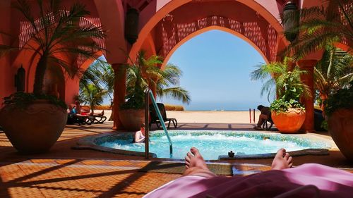 Low section of woman relaxing in swimming pool