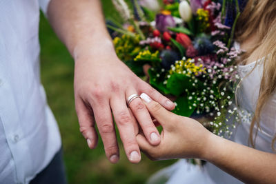 Midsection of couple holding hands