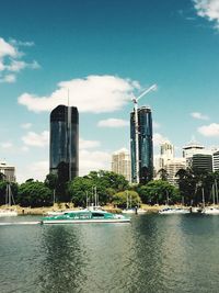 City at waterfront against cloudy sky