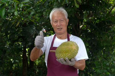 Man holding umbrella standing against plants