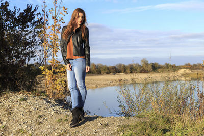 Woman standing by plants against sky
