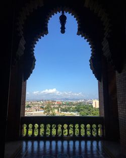 Cityscape seen through arch against clear sky