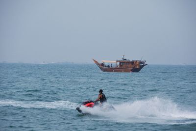 Man on jet boat in sea against clear sky