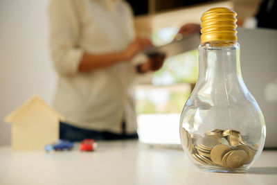 Close-up of coins in jar on table