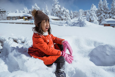 Portrait of young woman sitting on snow