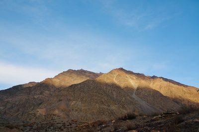 Scenic view of rocky mountains against blue sky