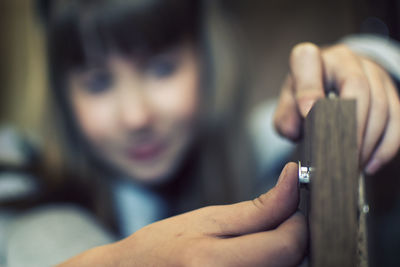 Close-up of people working on wood