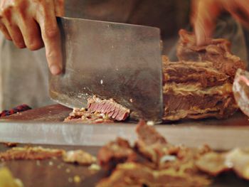 Cropped image of butcher cutting meat