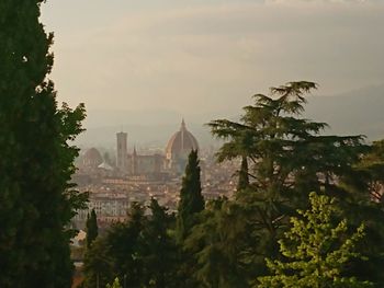 Panoramic view of trees and buildings against sky