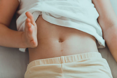 Midsection of woman lying on bed