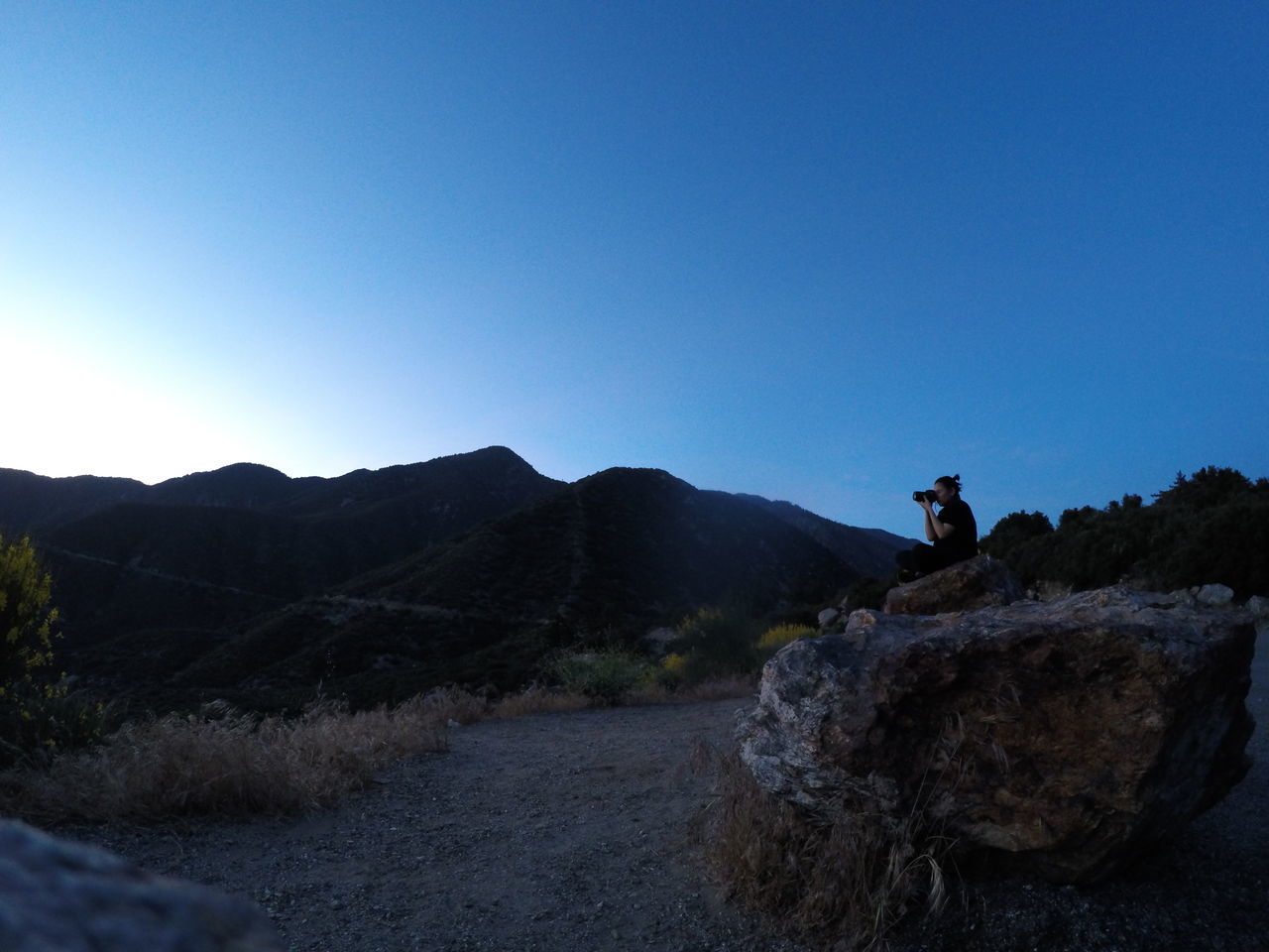 clear sky, copy space, mountain, tranquil scene, tranquility, blue, scenics, landscape, beauty in nature, nature, rock - object, non-urban scene, sunlight, mountain range, idyllic, hill, outdoors, road, water, remote