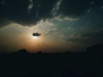 Silhouette of landscape against cloudy sky