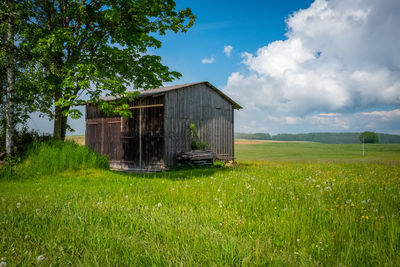Barn on field against sky