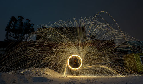 Low angle view of illuminated lights against sky at night