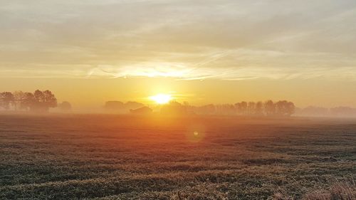 Scenic view of field against sky during sunset