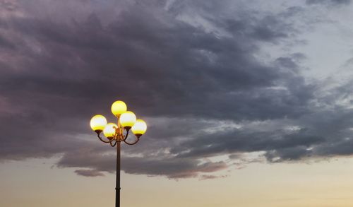 Low angle view of street light against cloudy sky