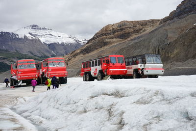 Cars on snowcapped mountains against sky