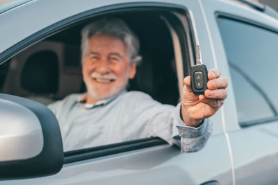 Close-up of man using mobile phone while sitting in car