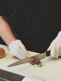 Midsection of man preparing food on cutting board