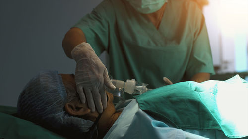 Midsection of doctor examining patient at home