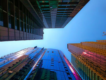 Low angle view of modern buildings against clear blue sky