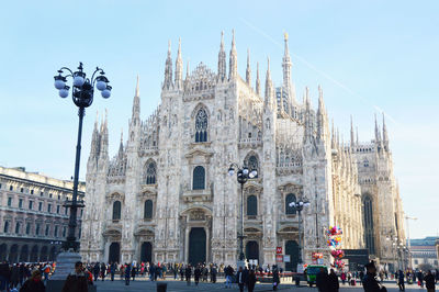 People in front of cathedral against clear sky