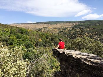 Man on cliff against sky