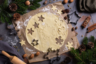 Christmas baking at home. fresh dough with rolling pin and snowflake cookies on a kitchen table.