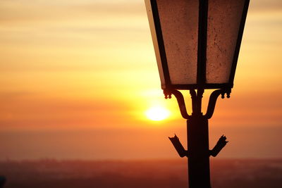 Close-up of silhouette cross against sky during sunset