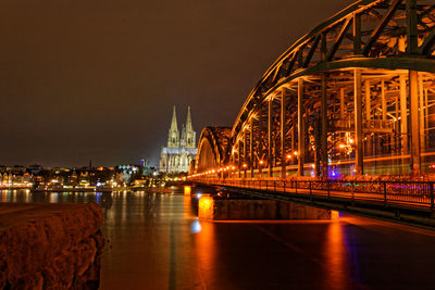 Illuminated bridge over river at night