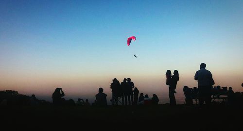 Silhouette people standing against clear sky during sunset