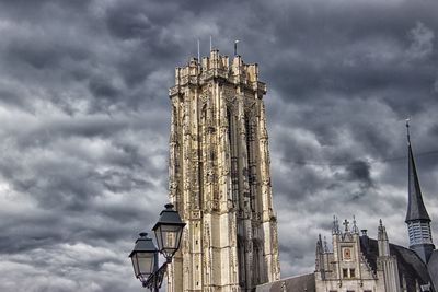 Low angle view of buildings in city against cloudy sky