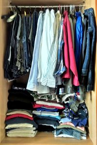 Various clothes hanging on rack at home