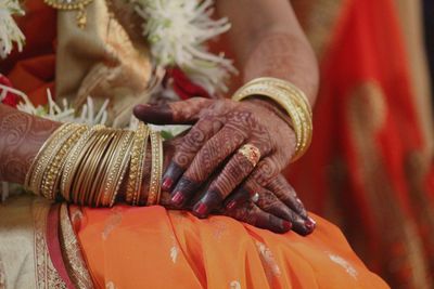 Midsection of bride wearing sari while sitting in wedding ceremony