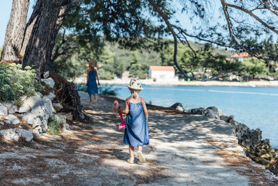 People walking on shore by trees