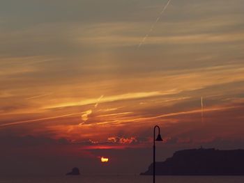 Scenic view of vapor trails in sky during sunset