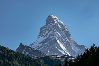 Scenic view of snowcapped mountains against clear blue sky