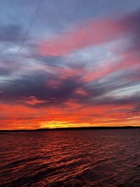 Scenic view of sea against dramatic sky during sunset