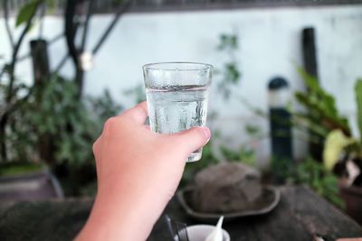 Close-up of hand holding glass of water