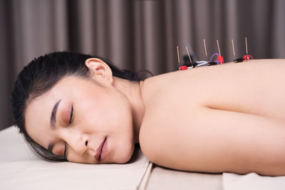 Close-up of woman lying on bed