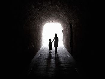 Silhouette siblings standing in archway